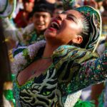 Vibrant street festival in Arica, Chile with colorful costumes and joyful expressions.