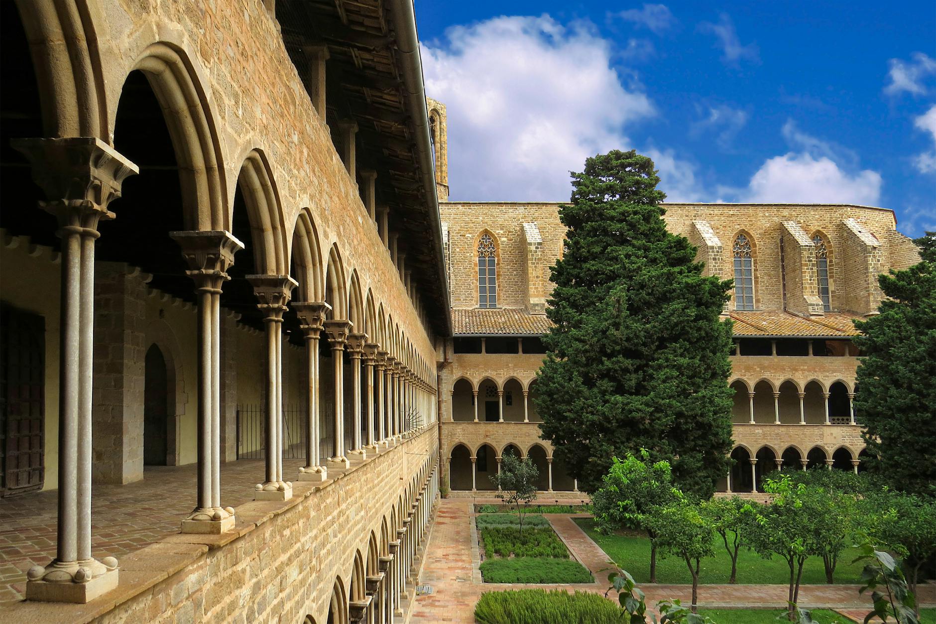 Beautiful Gothic architecture in a historical cloister in Barcelona, Spain showcasing arches and gardens.