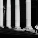A solitary figure walks past grand columns in Buenos Aires, Argentina.