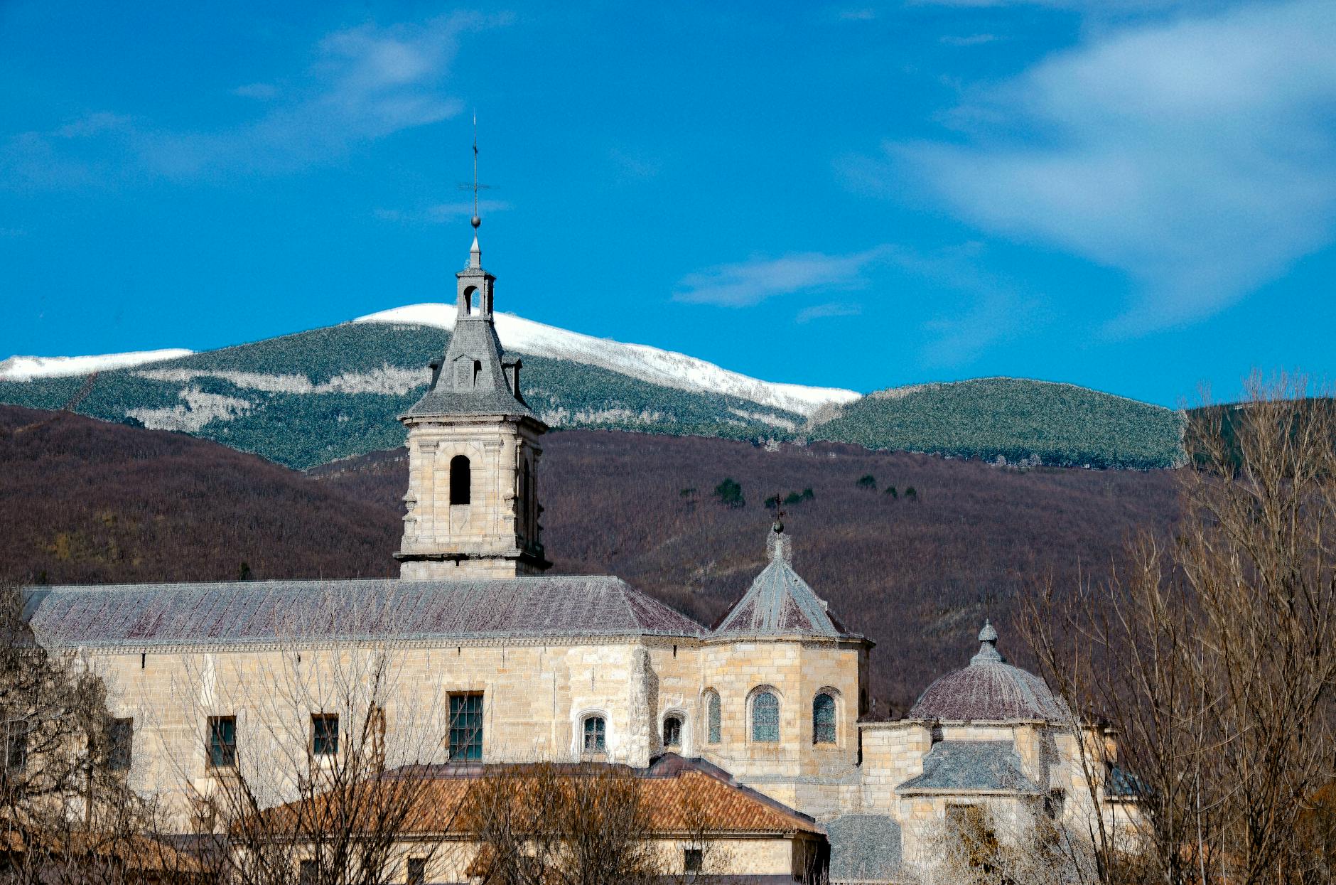 Monastery in Rascafría with mountain view under clear blue skies, Comunidad de Madrid.