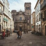 A lively scene in Santiago de Compostela with people enjoying a bustling medieval street view.