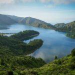 A breathtaking aerial view of Lagoa do Fogo's blue waters surrounded by lush green mountains.
