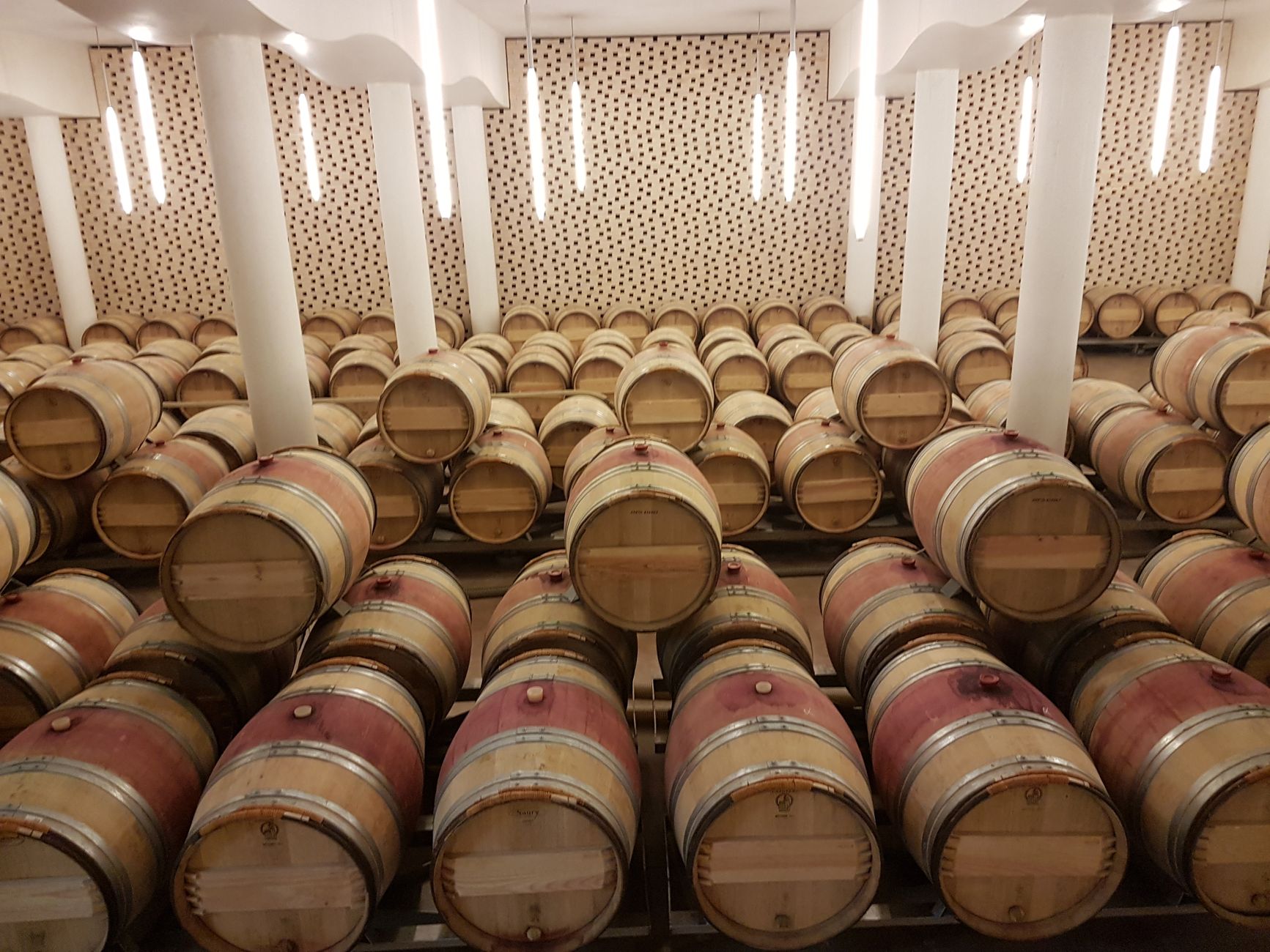 Wooden wine barrels stored in a Saint-Émilion cellar, France's renowned wine region.