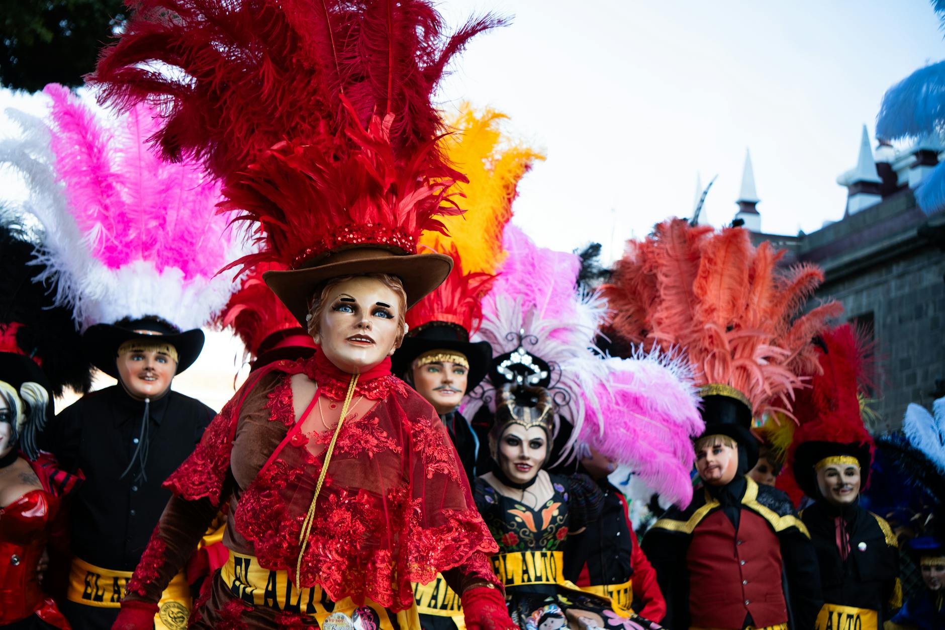 Colorful and festive costumes at Carnaval in Puebla, showcasing vibrant feathers and traditional attire.