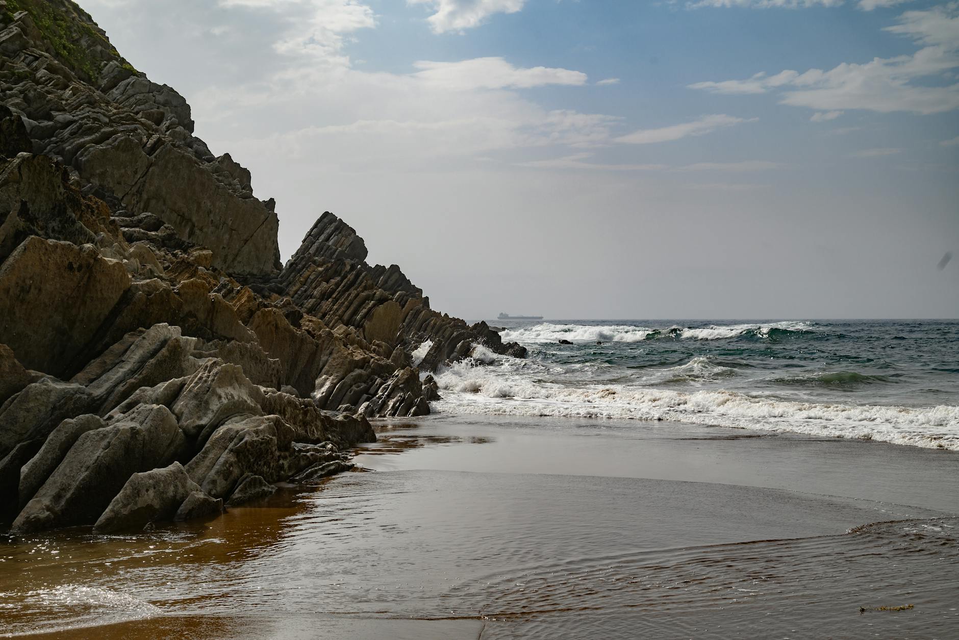 Explore the stunning rocky coastline of País Vasco with dramatic cliffs and crashing waves.