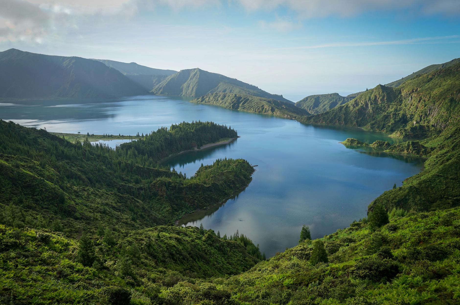 A breathtaking aerial view of Lagoa do Fogo's blue waters surrounded by lush green mountains.