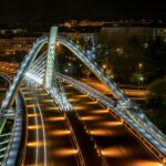 Majestic night view of the illuminated Ponte do Milenio bridge in Ourense, Spain, showcasing urban lights and architectural beauty.