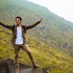 Excited hiker celebrating on a hill in Pachacamac, Perú, showcasing the rugged terrain.