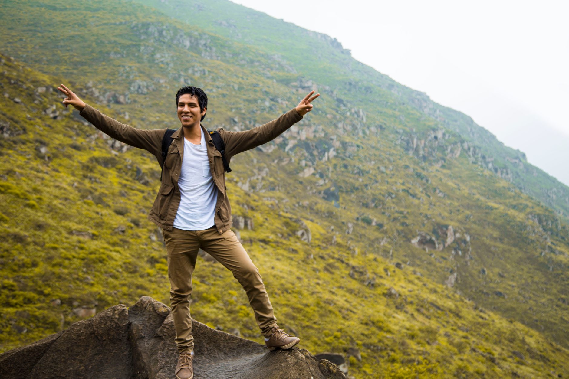 Excited hiker celebrating on a hill in Pachacamac, Perú, showcasing the rugged terrain.
