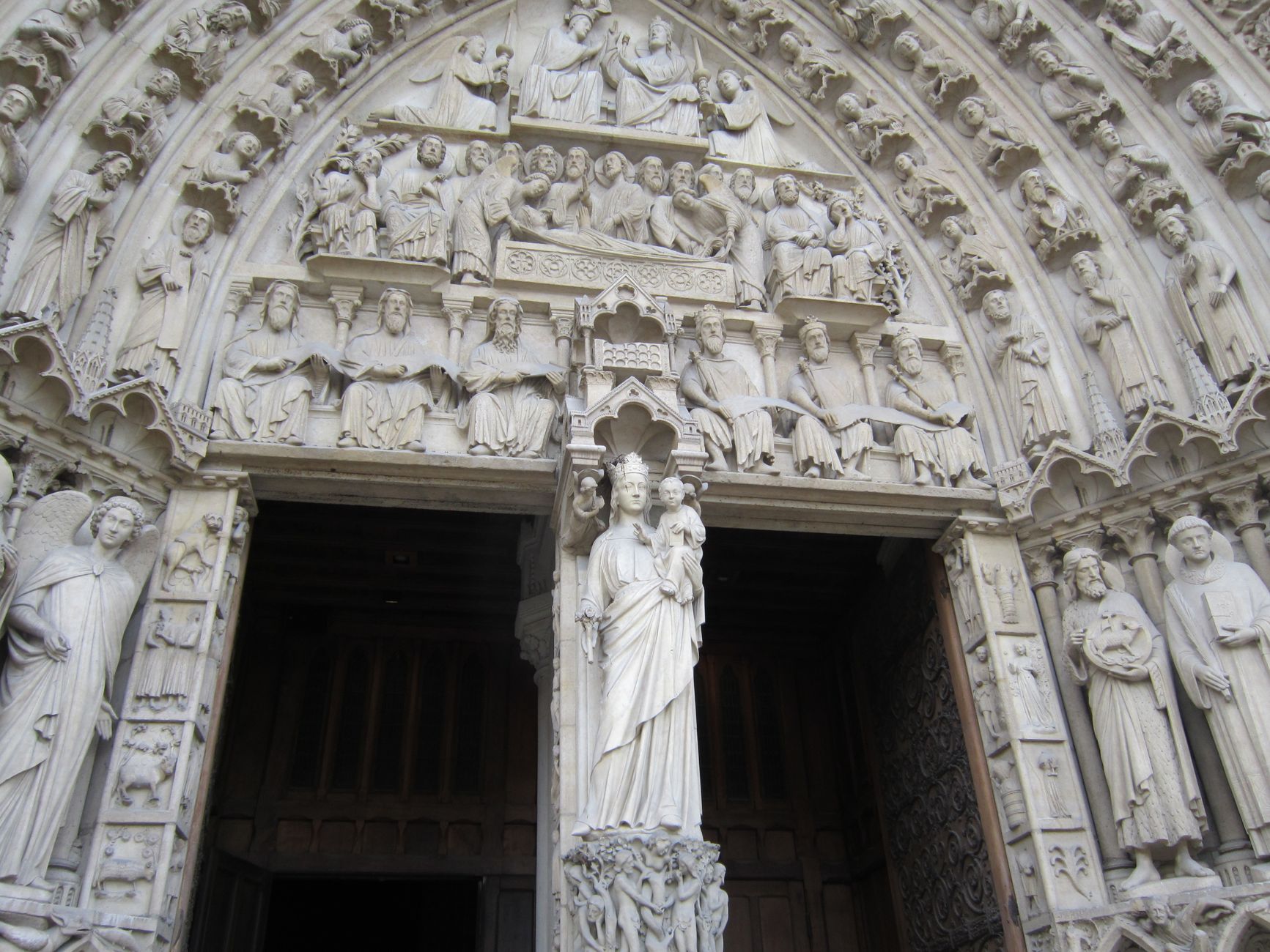 Detailed view of the ornate Gothic facade at the Notre-Dame Cathedral in Paris, showcasing intricate sculptures.