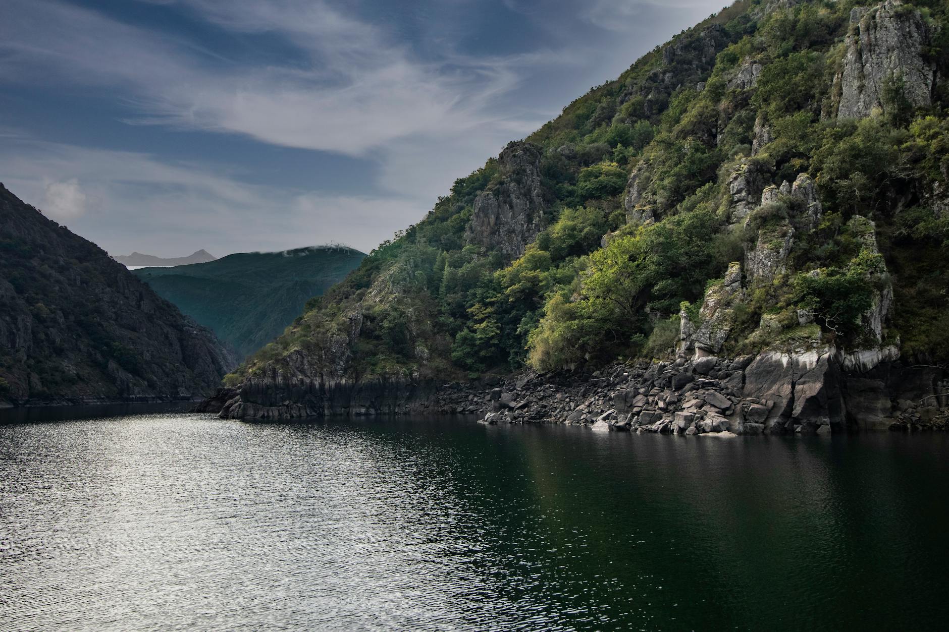A tranquil nature scene of a river canyon surrounded by lush cliffs in Ourense, Spain.