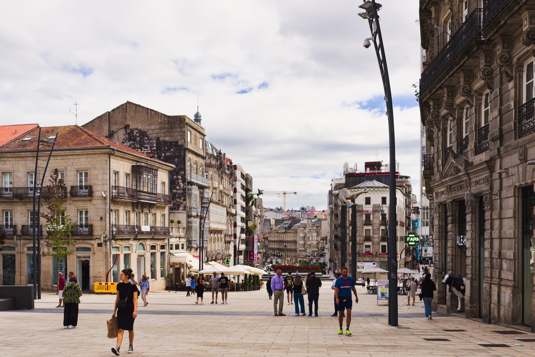 Street view of Vigo, Spain showcasing urban architecture and pedestrians in a lively square.