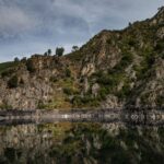 Tranquil rocky landscape with water reflection in Ourense, Spain's natural beauty.