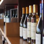 Close-up of wine bottles on a wooden shelf in a Valencia winery.