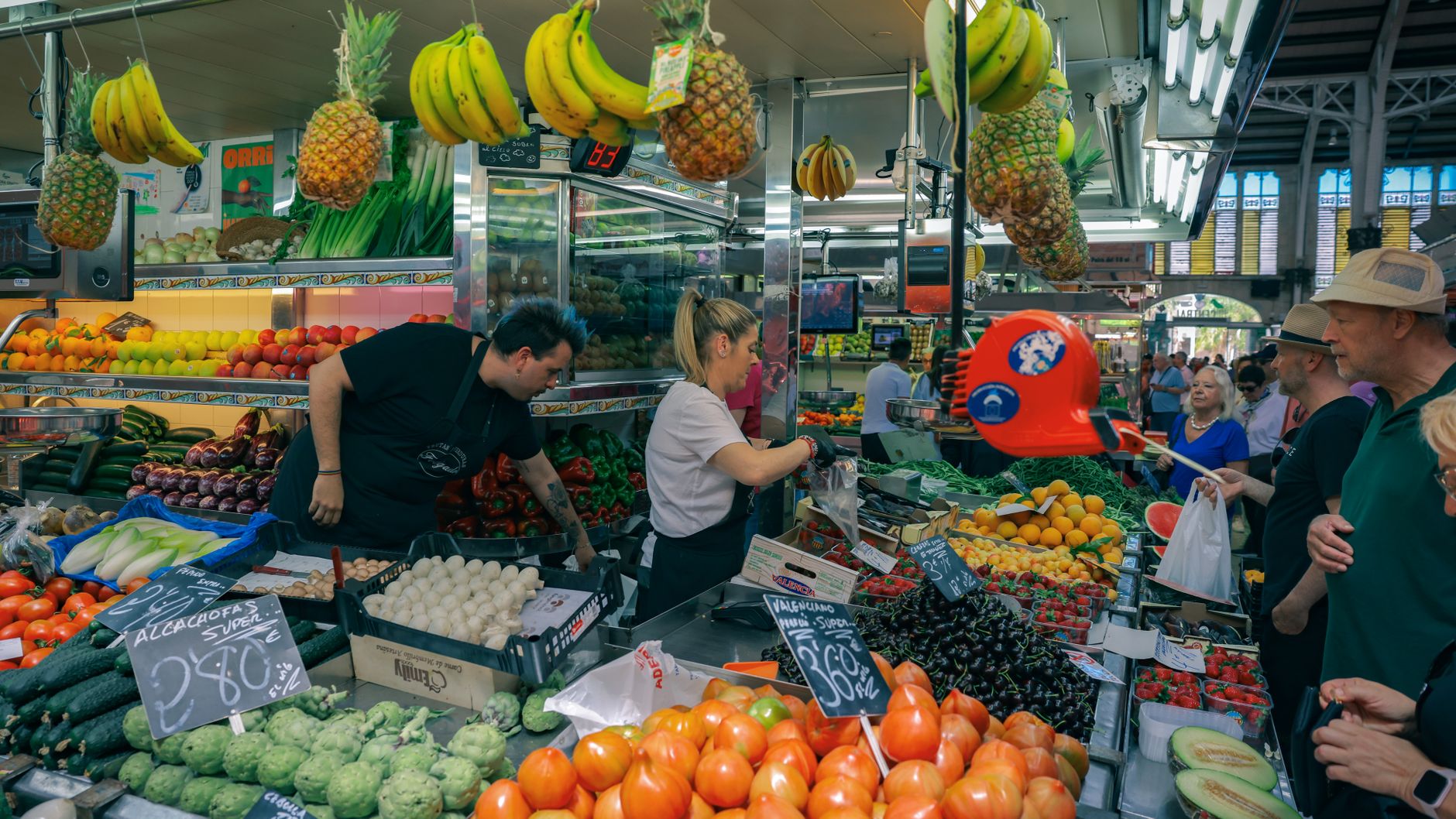 Busy marketplace in Valencia with diverse fruits and vegetables.