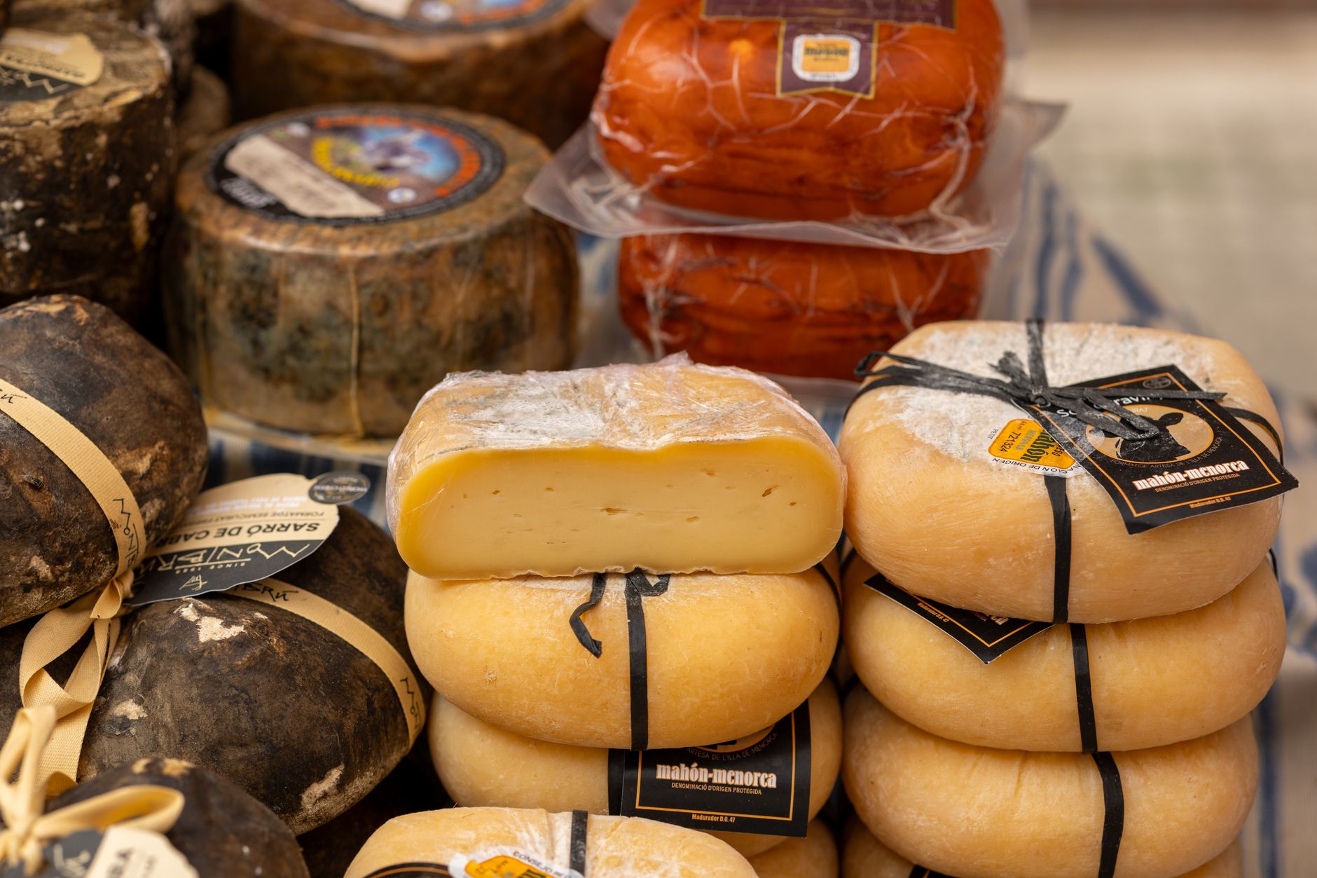 Assorted traditional Spanish cheeses displayed at a market stall in Palma, Spain.