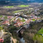 Stunning aerial photograph of Puentedey village in Castilla y León, Spain, showcasing unique natural bridge formation.
