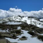 Stunning view of snow-covered peaks and dramatic clouds in Castilla y León, Spain.