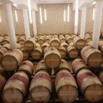 Wooden wine barrels stored in a Saint-Émilion cellar, France's renowned wine region.