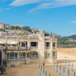 A sunny day view of the beautiful beachfront building in San Sebastián, showcasing its architectural elegance and vibrant surroundings.
