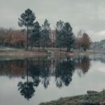 Tranquil autumn landscape with trees reflected in a lake at Cachamuíña, Galicia, Spain.