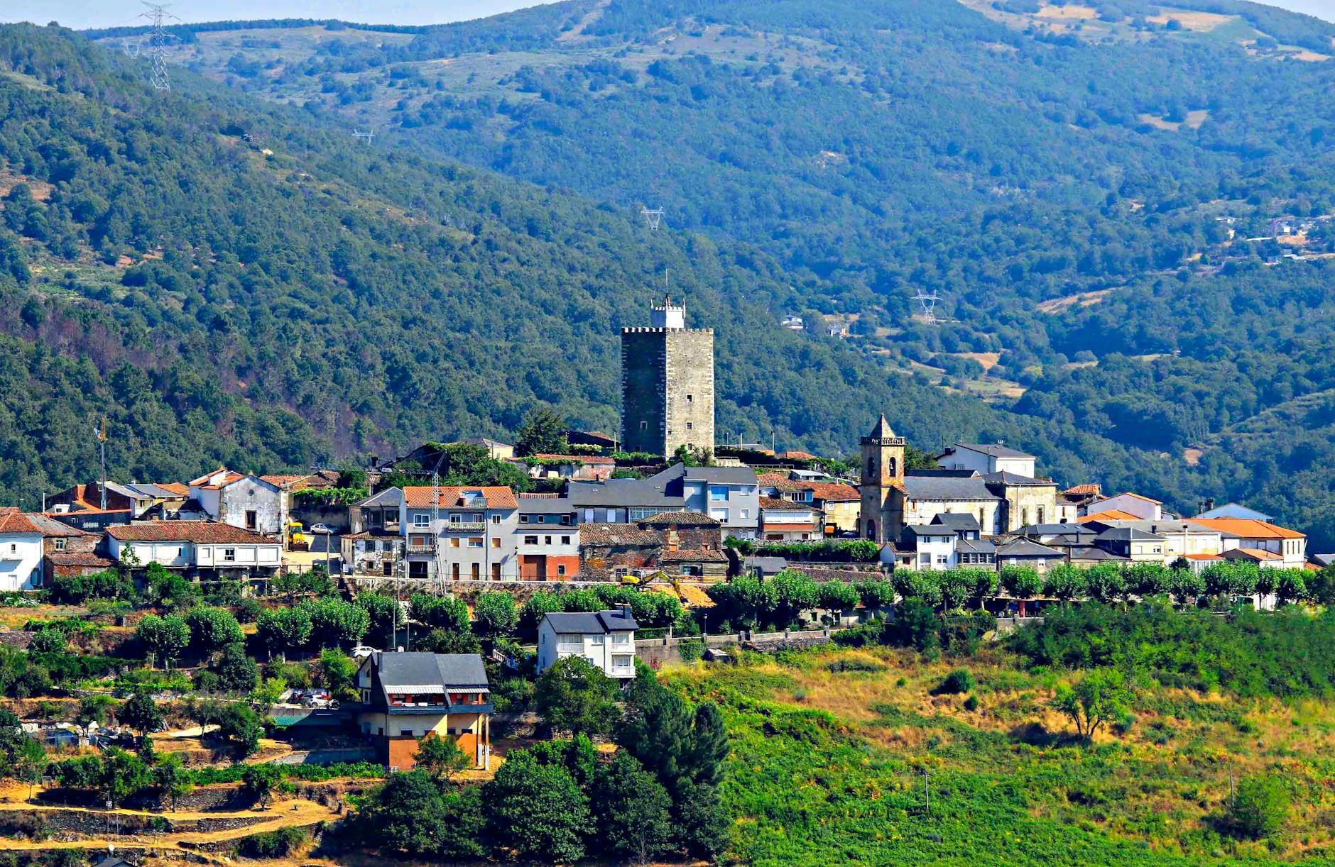 Picturesque landscape of Viana do Bolo village with historic tower and lush mountains.
