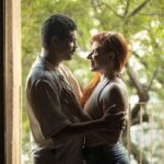 A loving couple sharing a tender moment by a doorway with natural light flowing in. Captured in Buenos Aires.