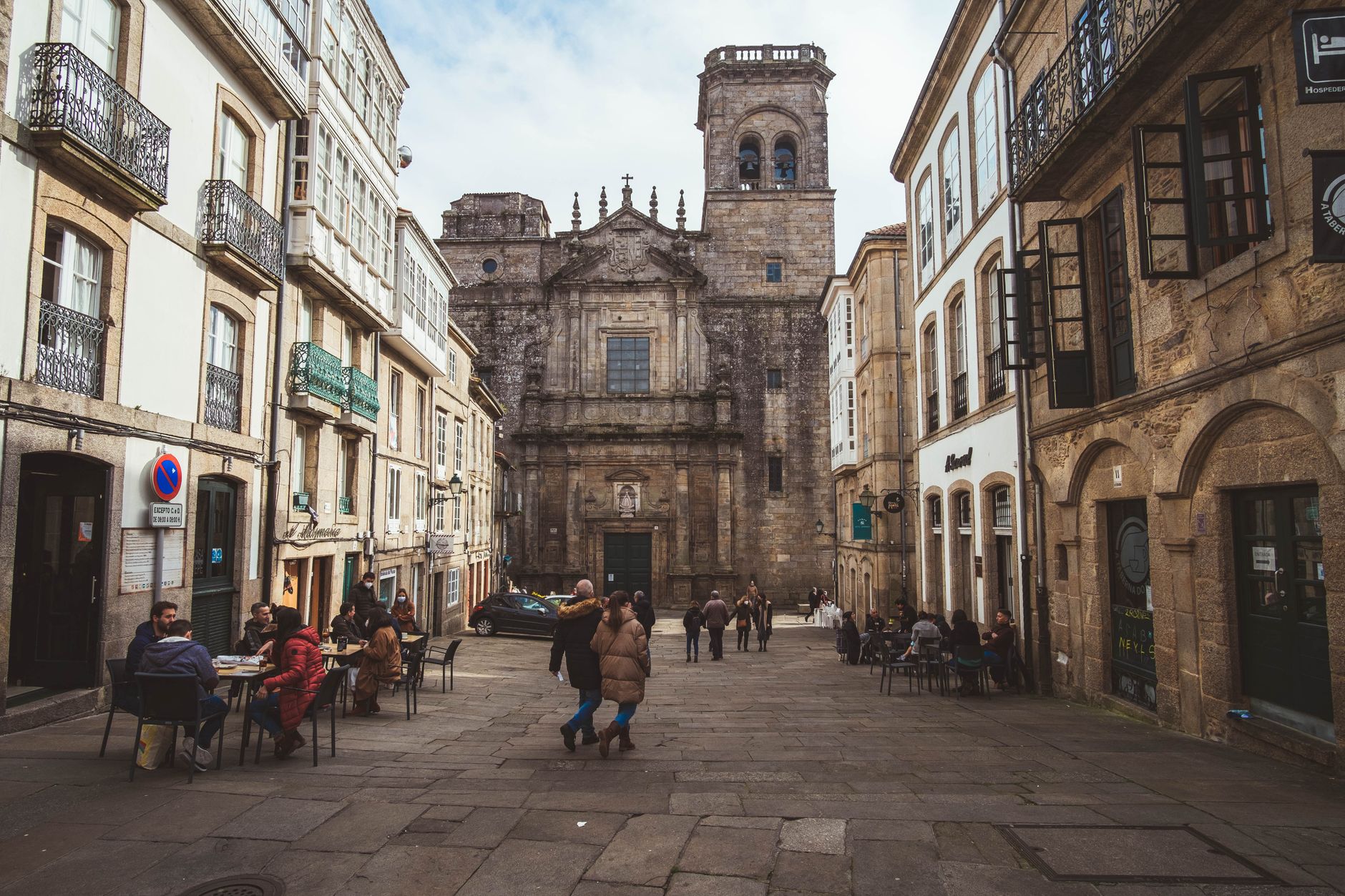A lively scene in Santiago de Compostela with people enjoying a bustling medieval street view.