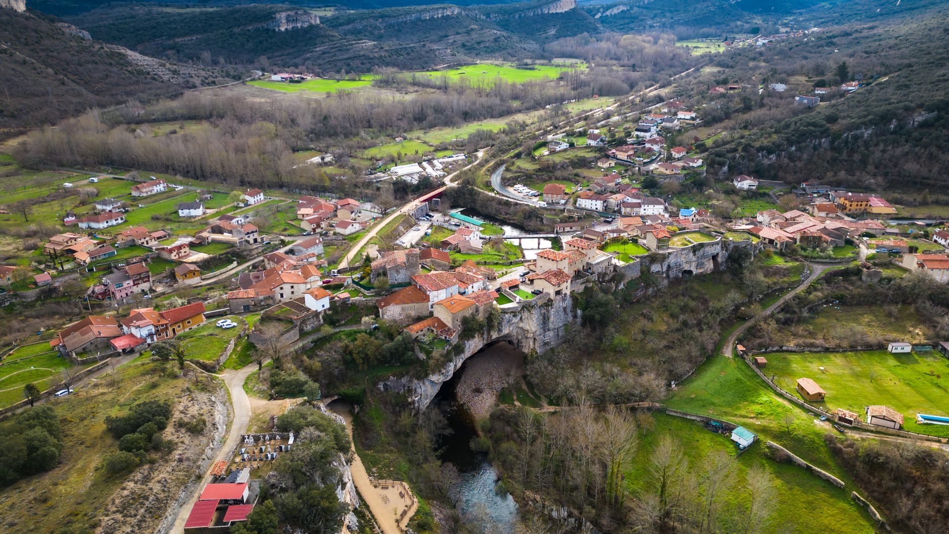 Stunning aerial photograph of Puentedey village in Castilla y León, Spain, showcasing unique natural bridge formation.
