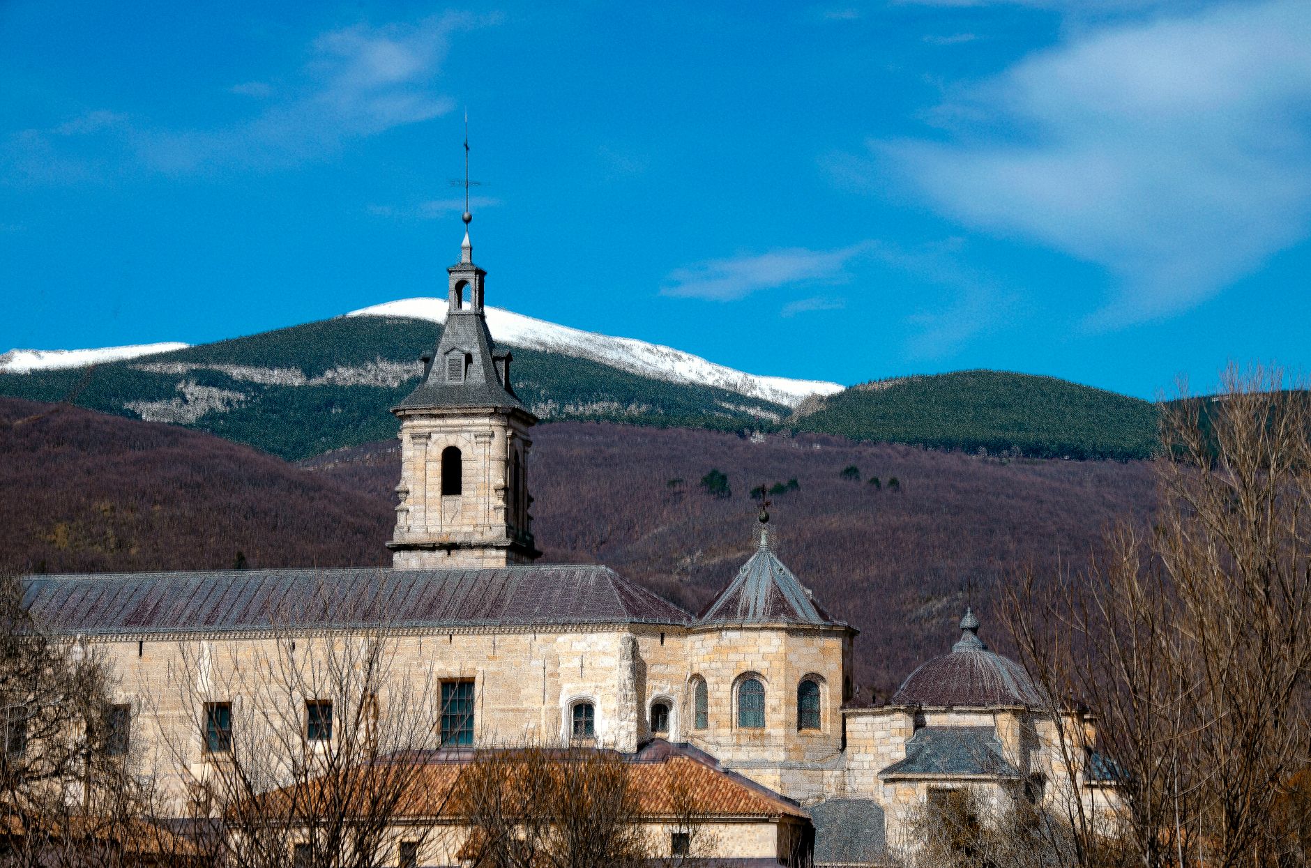 Monastery in Rascafría with mountain view under clear blue skies, Comunidad de Madrid.