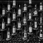 A black and white photo showcasing an elegant wine rack filled with various bottles.