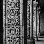 Intricate stone columns at an ancient Arequipa monastery, showcasing detailed carvings in black and white photography.