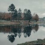 Tranquil autumn landscape with trees reflected in a lake at Cachamuíña, Galicia, Spain.
