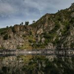 Tranquil rocky landscape with water reflection in Ourense, Spain's natural beauty.