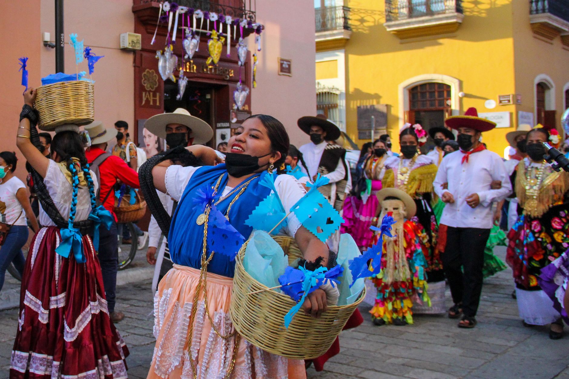 Colorful street parade in Oaxaca with traditional costumes and festive atmosphere.