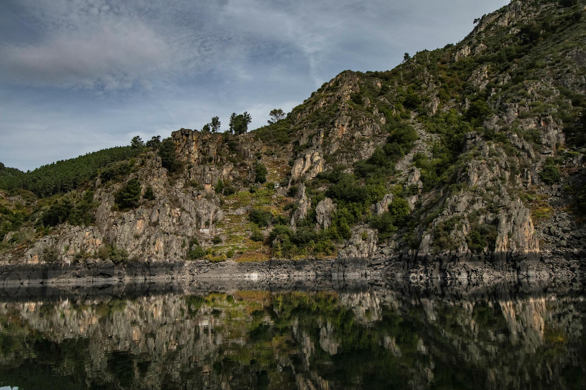 Tranquil rocky landscape with water reflection in Ourense, Spain's natural beauty.