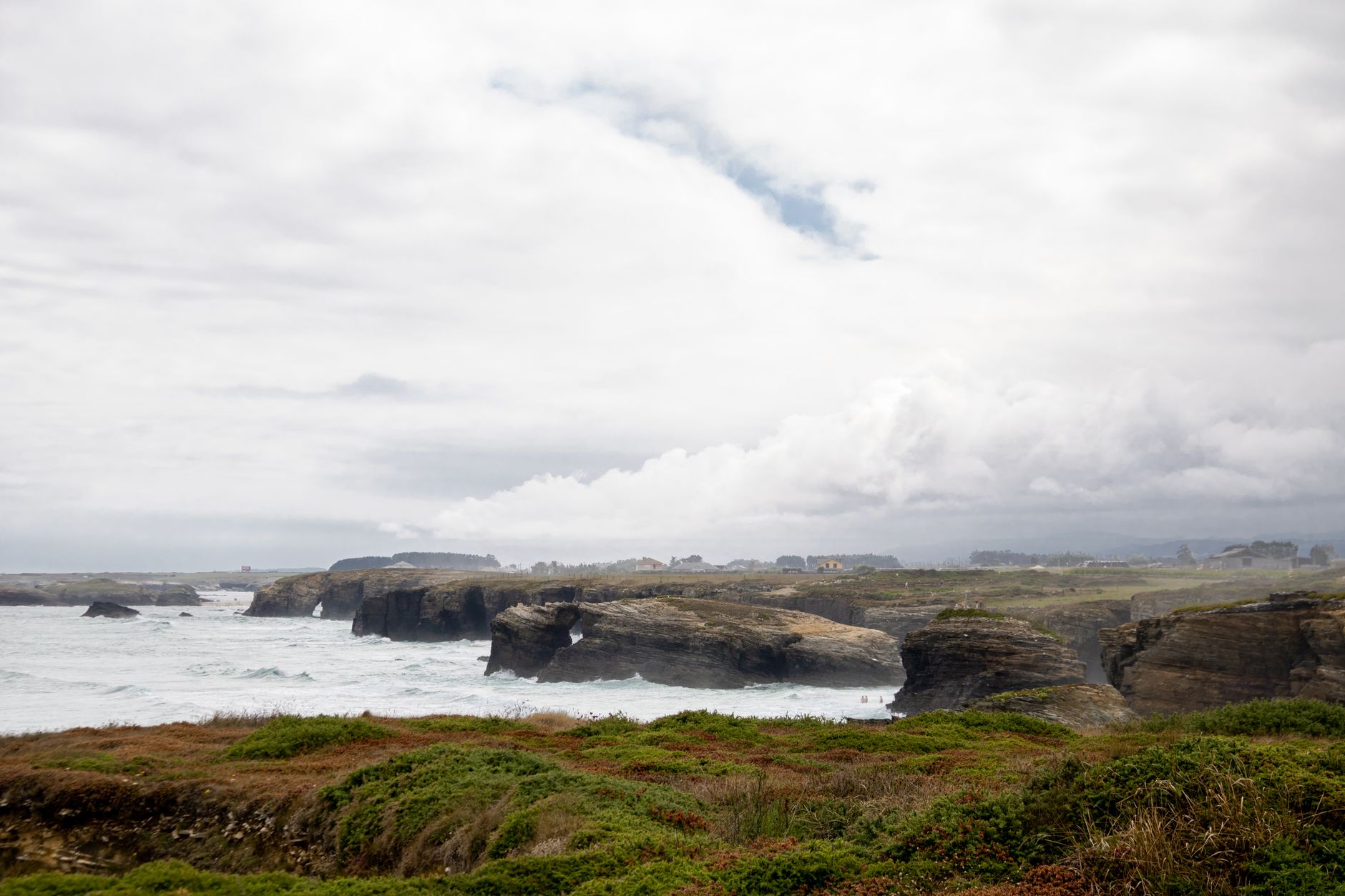 Explore the stunning coastal cliffs of Lugo, Spain with lush greenery and crashing waves.