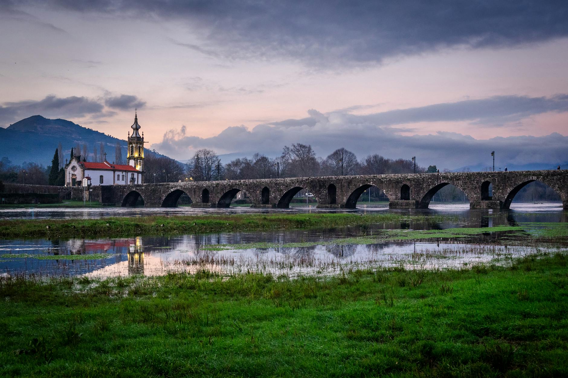 Scenic view of Ponte de Lima's historic bridge and church at twilight.
