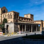 Beautiful view of the Basilica of San Vicente in Ávila, capturing Romanesque architecture under a clear blue sky.