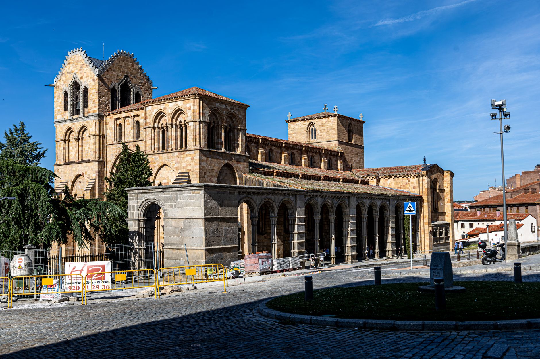 Beautiful view of the Basilica of San Vicente in Ávila, capturing Romanesque architecture under a clear blue sky.