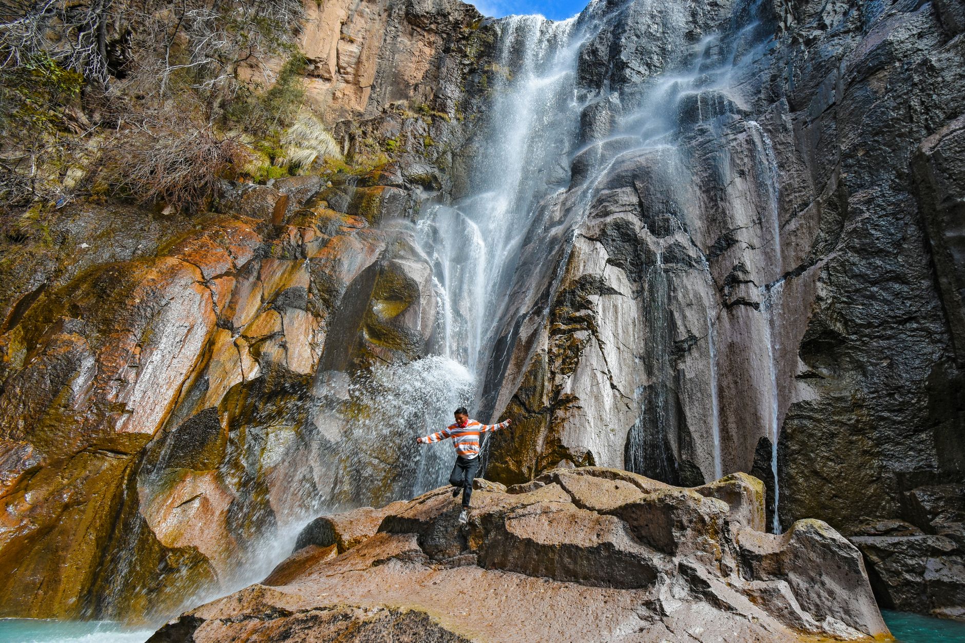 Person joyfully experiencing the majesty of Cusárare Waterfall, Guachochi, Mexico.