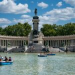 People enjoy boating at the iconic Retiro Park with Alfonso XII Monument, Madrid.