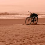 A solitary bicycle rests on a tranquil Guaratuba beach at sunset, capturing a peaceful moment.