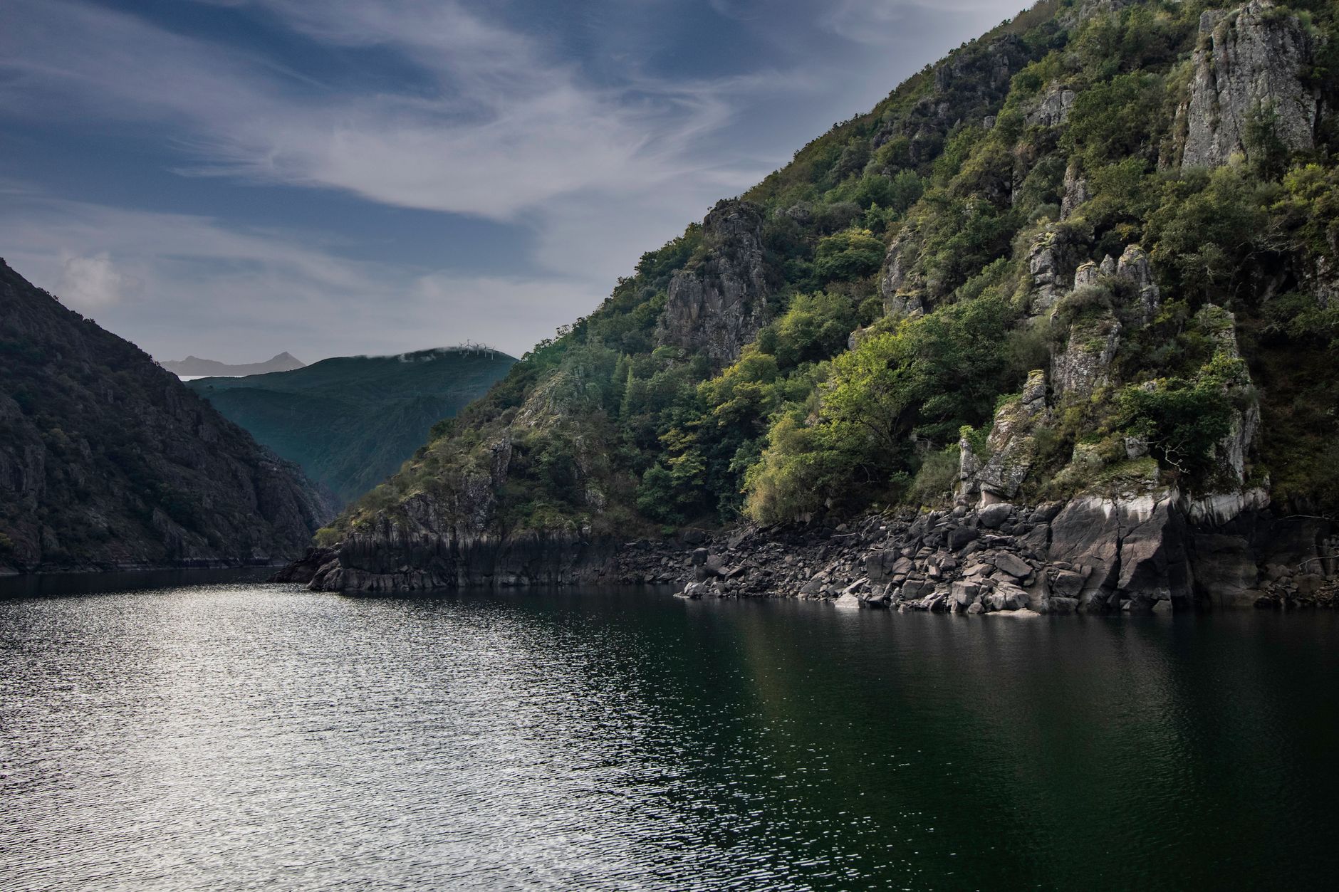 A tranquil nature scene of a river canyon surrounded by lush cliffs in Ourense, Spain.