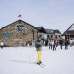 Skiers in a vibrant winter setting at La Cabaña, surrounded by snow-covered slopes and lively atmosphere.