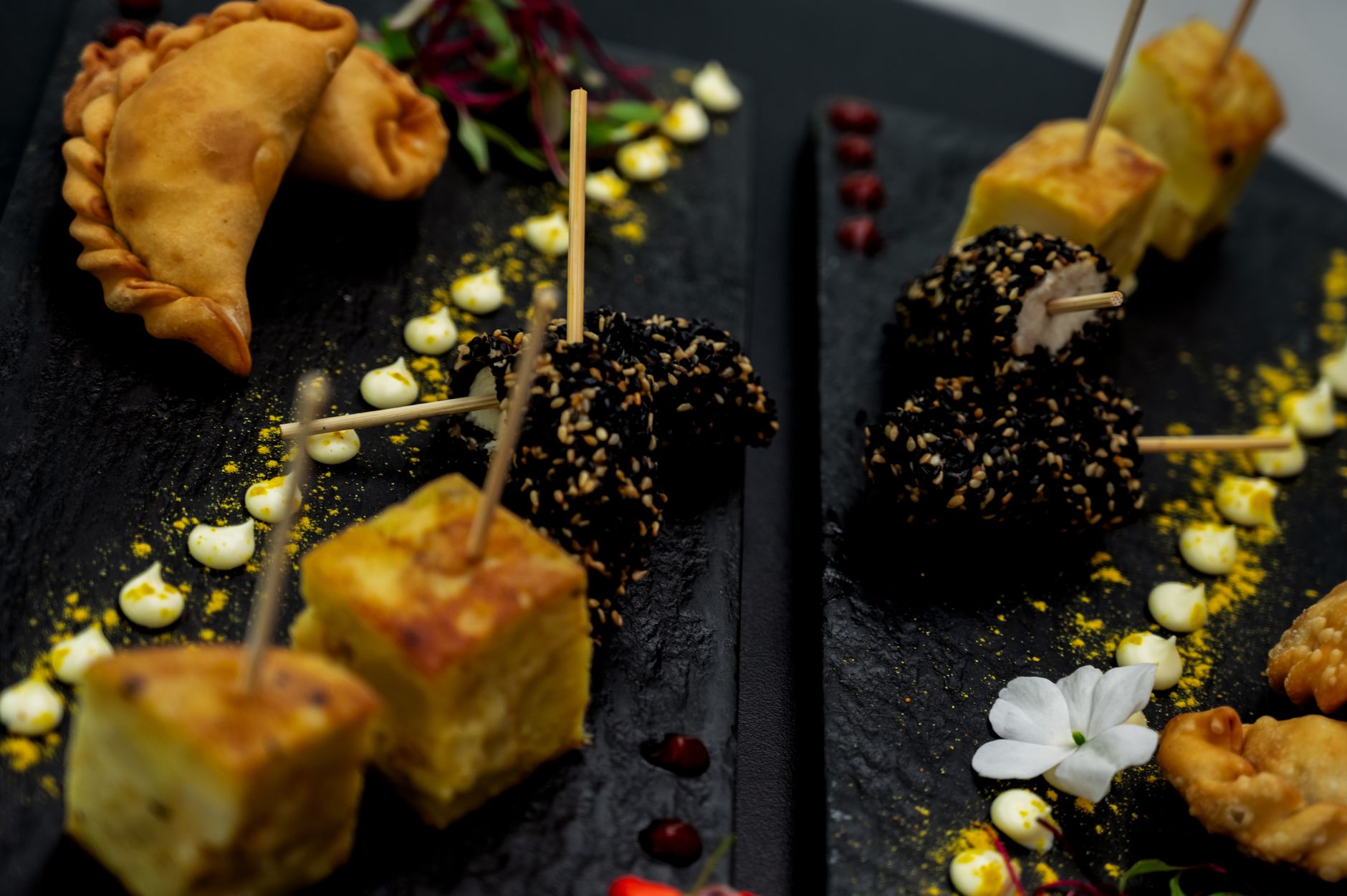 A selection of gourmet Argentinian appetizers elegantly presented on black slate platters.